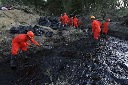 Trabajadores limpian el derrame de petr&oacute;leo. 