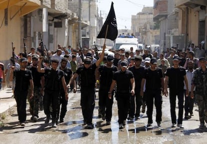 Un grupo de combatientes islamistas ondea su bandera en el funeral por un compa&ntilde;ero ca&iacute;do ayer cerca de Alepo.