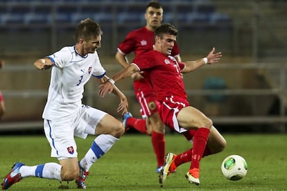 El jugador de Gibraltar Jeremy Lopez, con el balón, es marcado por el eslovaco Pavol Farkas.