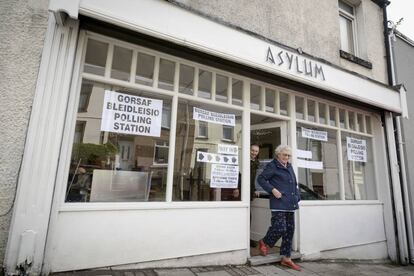 Una pareja abandona una peluquería llamada Asylum in Merthyr Tydfil (Gales), utilizada como centro electoral.