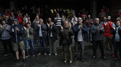 Un grupo de personas aplauden la llegada de las urnas en el exterior de la escola Collaso i Gil de Barcelona. 