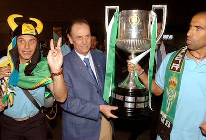 Manuel Ruiz de Lopera (centro) junto a los jugadores del Betis, Joaquín Sánchez y Washington Eduardo Tais, sujetan el trofeo de la Copa del Rey de Fútbol tras ganar al Osasuna a su llegada a Sevilla, el 12 de junio de 2005. 
