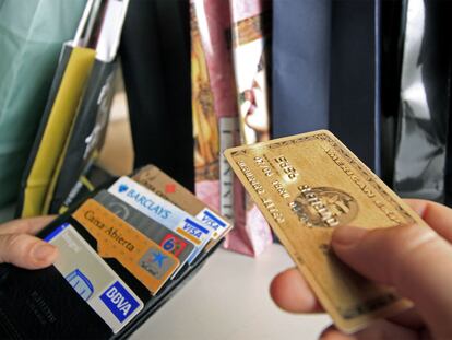 Una persona saca una tarjeta de la cartera para pagar.