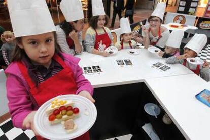 Varios niños participan en Torrelodones en la iniciativa de recogida de alimentos patrocinada por cocineros españoles.