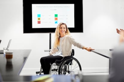 Una mujer con discapacidad realiza una presentación en una empresa.