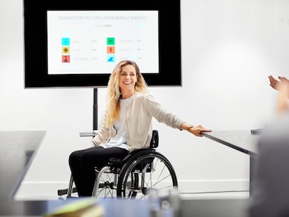 Una mujer con discapacidad realiza una presentación en una empresa.