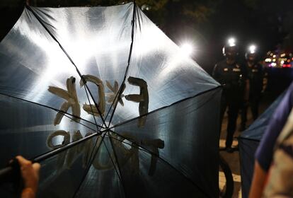 Un manifestante muestra un paraguas con un mensaje durante el primer día de la Convención Nacional Republicana en Charlotte, Carolina del Norte (Estados Unidos), el 24 de agosto de 2020.