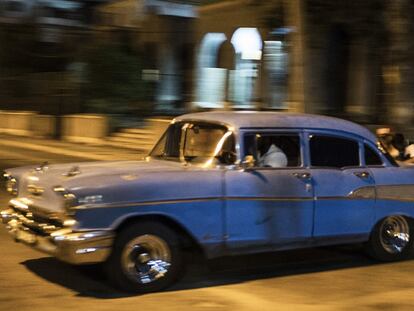 Varios jóvenes empujan uno de los viejos coches que recorren La Habana para arrancarlo de nuevo.