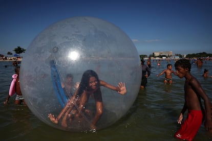 Niños juegan en un estanque artificial conocido como Piscinao de Ramos, o piscina grande, durante una ola de calor en los suburbios del norte de Río de Janeiro, Brasil, el 16 de febrero de 2025. 