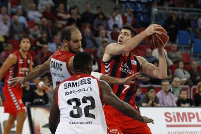 Shengelia, del Laboral Kutxa, defiende el balón ante dos jugadores de La Bruixa.