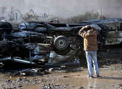 Un iraquí contempla un amasijo de coches destruidos por la explosión de una bomba ayer en Bagdad.