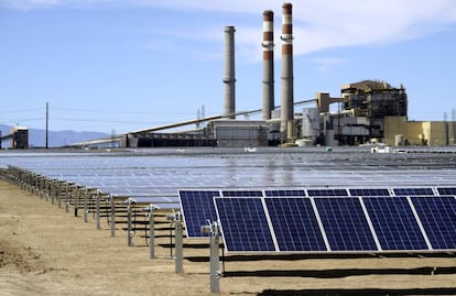 Paneles solares en Pueblo, Colorado. Al fondo, una planta de carbón de Xcel Energy.