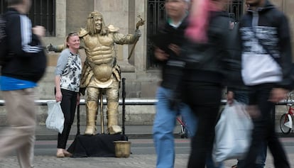 Una turista es fa una foto amb una estàtua de la Rambla.