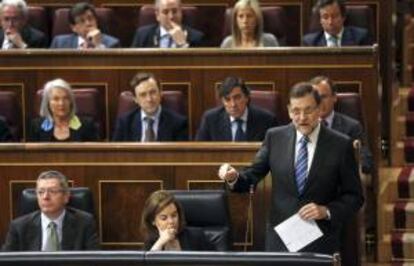 El presidente del Gobierno, Mariano Rajoy (d), junto a la vicepresidenta, Soraya Sáenz de Santamaría (c - abajo), y el ministro de Justicia, Alberto Ruiz Gallardón (i - abajo), durante su intervención en la sesión de control al Ejecutivo. EFE/Archivo