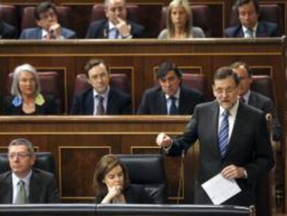 El presidente del Gobierno, Mariano Rajoy (d), junto a la vicepresidenta, Soraya Sáenz de Santamaría (c - abajo), y el ministro de Justicia, Alberto Ruiz Gallardón (i - abajo), durante su intervención en la sesión de control al Ejecutivo. EFE/Archivo
