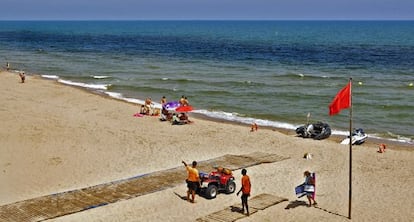 Playa de Tavernes de la Valldigna, el miércoles, con la bandera roja por la extensión de la mancha de fitoplancton.