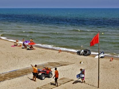 Playa de Tavernes de la Valldigna, el miércoles, con la bandera roja por la extensión de la mancha de fitoplancton.