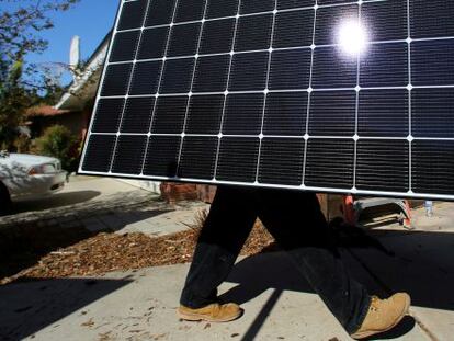 Un operario transporta un panel solar en San Diego (EE UU).