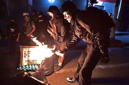 Um homem ateia fogo em um saco de lixo durante o protesto contra a Copa.