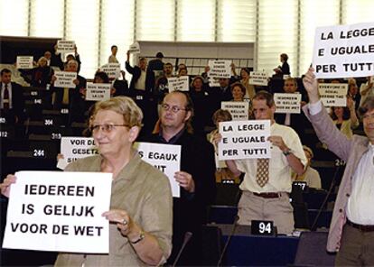 Los diputados de la izquierda muestran pancartas contra Berlusconi con "Todos somos iguales ante la ley".