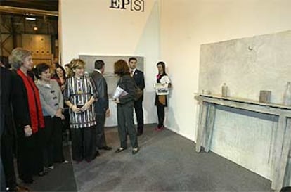 La Reina, Carmen Laffón y la ministra de Cultura, en el stand de EL PAÍS ante la escultura <i>Mesa improvisada.</i>