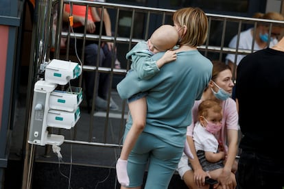 Una mujer sostiene a un niño hospitalizado en el centro sanitario Ohmatdyt, este lunes tras el ataque ruso.