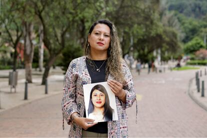 Mariluz Beltrán sostiene una foto de su hermana Yudi Angélica, víctima de feminicidio, en una imagen tomada en el centro de Bogotá, el 6 de mayo de 2023.