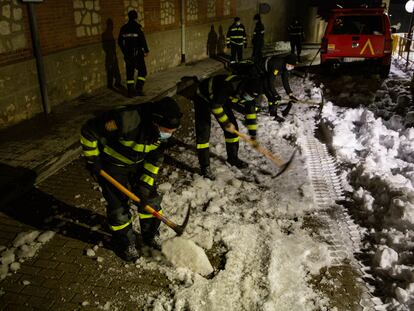 Militares de la UME rompen con ayuda de picos la capa de hielo formada en una calle de Loeches.