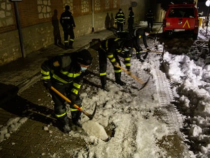 Militares de la UME rompen con ayuda de picos la capa de hielo formada en una calle de Loeches.