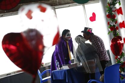 Un hombre disfrazado como el Guazn observa el momento en que una pareja se besa durante una boda simblica conmemorando el da de San Valentn, el 13 de febrero de 2016, en Ciudad de Mxico (Mxico). Para esta fecha, parejas pagan aproximadamente 7 dolares para recibir anillos simblicos y certificados de boda falsos.