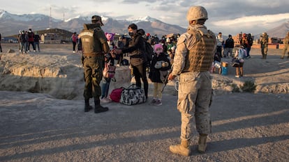 Agentes de la policía fronteriza chilena controlan a los migrantes que cruzaron ilegalmente a Chile desde la frontera con Bolivia