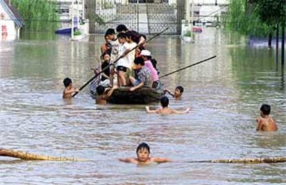 Un grupo de niños juega en un área inundada de la ciudad china de Wuhan, cerca del río Changjiang.