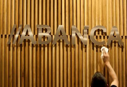 Un operario limpia el logotipo de Abanca. EFE/Archivo