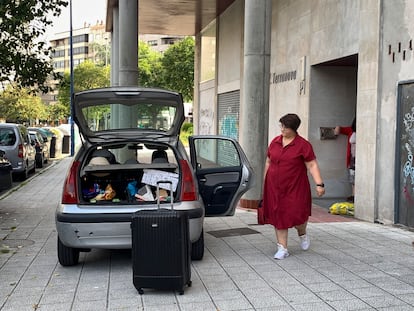 Una mujer carga su equipaje en un vehículo tras ser desahuciada de su vivienda en Vigo, el 9 de junio.