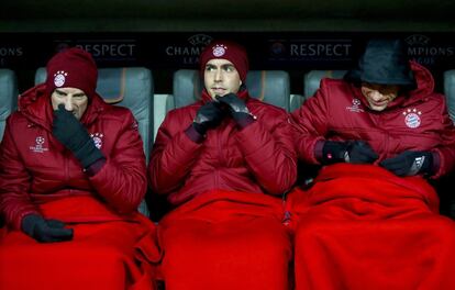 Franck Ribery, Philipp Lahm y Thomas del Bayern se sientan en el banquillo resguardados del frio, antes del partido de Champions League entre el FC Bayern Muenchen y el Club Atlético de Madrid en Allianz Arena.