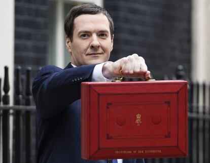El ministro del Tesoro, George Osborne, muestra el maletín rojo que contiene el Presupuesto mientras abandona el Nº 11 de Downing Street donde está la sede del Exchequer de camino al Parlamento.