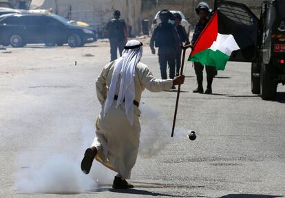 Un manifestante palestino pasa junto a un bote de gas lacrimógeno lanzado por las fuerzas israelíes durante una protesta en solidaridad con los prisioneros palestinos detenidos en cárceles israelíes, cerca de la prisión de Ofer.