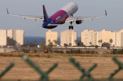 Un avión despega del aeropuerto de Alicante-Elche sobre el barrio de Urbanova de Alicante.