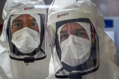Desde la izquierda, Diego Muñoz y Jorge Ripoll vestidos con equipos filtrantes de aire individuales y trajes de seguridad para zonas de alto riesgo biológico en el Laboratorio de Alta Seguridad Biológica con nivel P3-Plus.