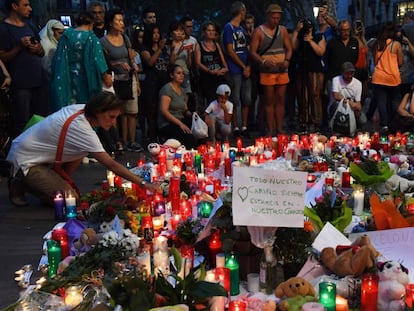 Pessoas deixam flores e velas em homenagens às vítimas em Las Ramblas.