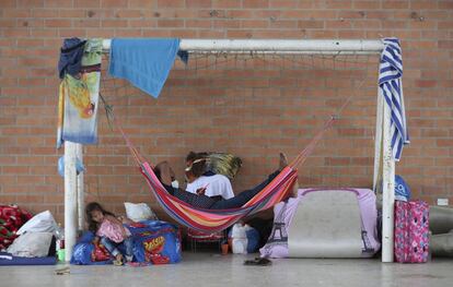 Venezolanos descansan bajo una portería de fútbol en un albergue instalado en un centro comunitario en Arauquita.
