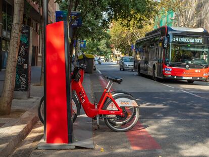 Un autobús urbano pasa junto a una estación de bicis de alquiler municipal en Barcelona.