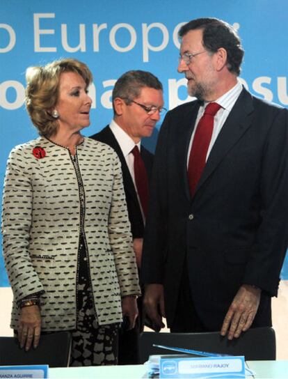 Aguirre, Rajoy y Gallardón (detrás), ayer en un acto del PP.