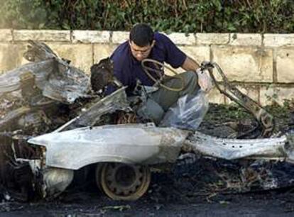 Una nueva oleada de atentados deja cinco heridos en Jerusalén
Un policía examina los restos del coche bomba que ha estallado esta mañana en la Ciudad Santa (Reuters).