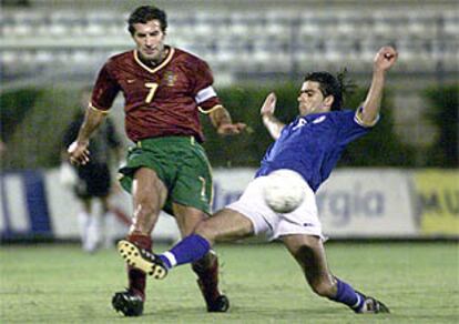 Un defensor entra a Figo durante el partido Chipre-Portugal, en Larnaca.