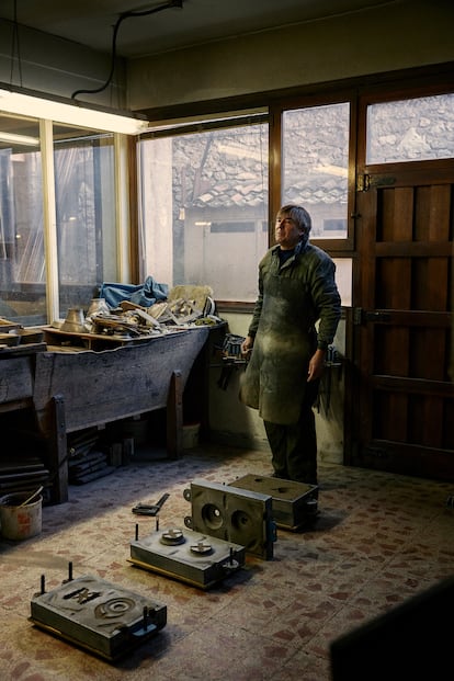 Artisan Gorete Pascual has been working in this trade for 45 years. Here, he poses next to the boxes of pressed sand prepared with molds to hold the molten tin. At left, tin designs for sale in the store located above the Pedraza workshop.