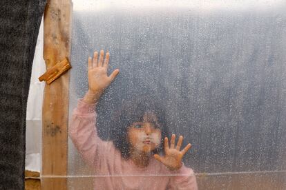 Una niña palestina desplazada mira a través de una lámina de plástico que cubre su refugio de un campamento de tiendas de campaña en Jan Yunis, este jueves en la Franja.