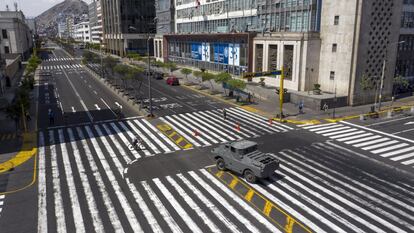 Un vehículo blindado vigila un cruce en una avenida de Lima.