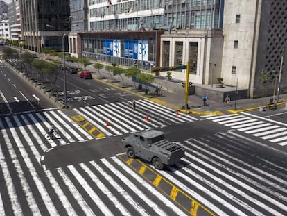 Un vehículo blindado vigila un cruce en una avenida de Lima.