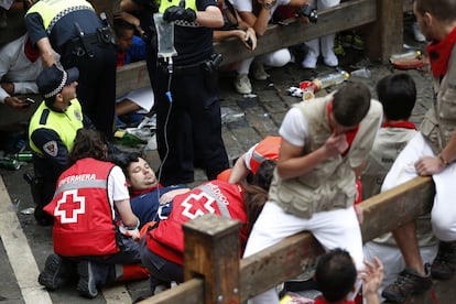 El resto de la manada ha seguido el recorrido protagonizando varios momentos de peligro, y con al menos tres heridos por asta de toro. En la imagen, personal de emergencias atienden las heridas del corredor.